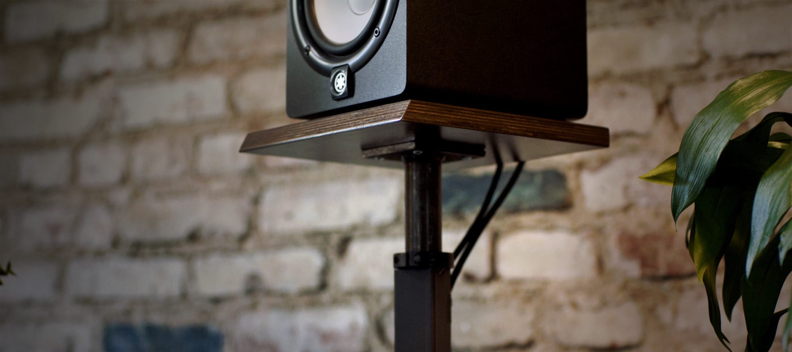 Yamaha HS8 Studio Monitors sitting on top of brown Output speaker stands.
