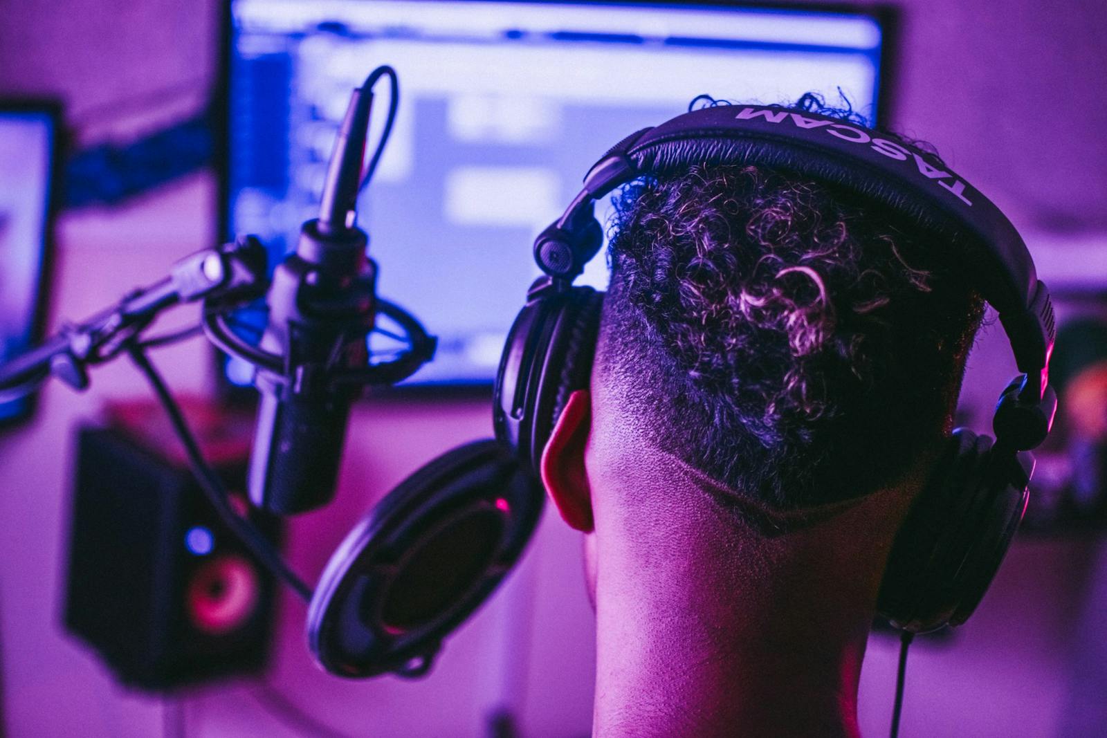 Person recording music in home studio with plugins on screen.